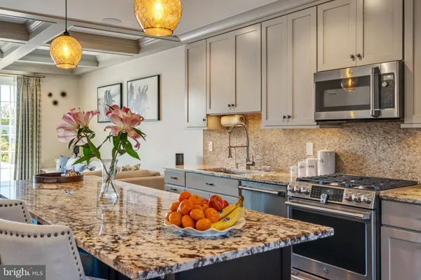 a kitchen with stainless steel appliances granite countertop a sink a stove and a wooden cabinets