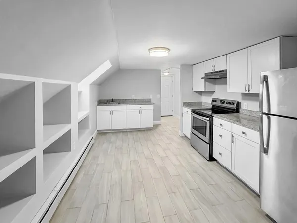 a kitchen with granite countertop a refrigerator oven a sink dishwasher and white cabinets with wooden floor