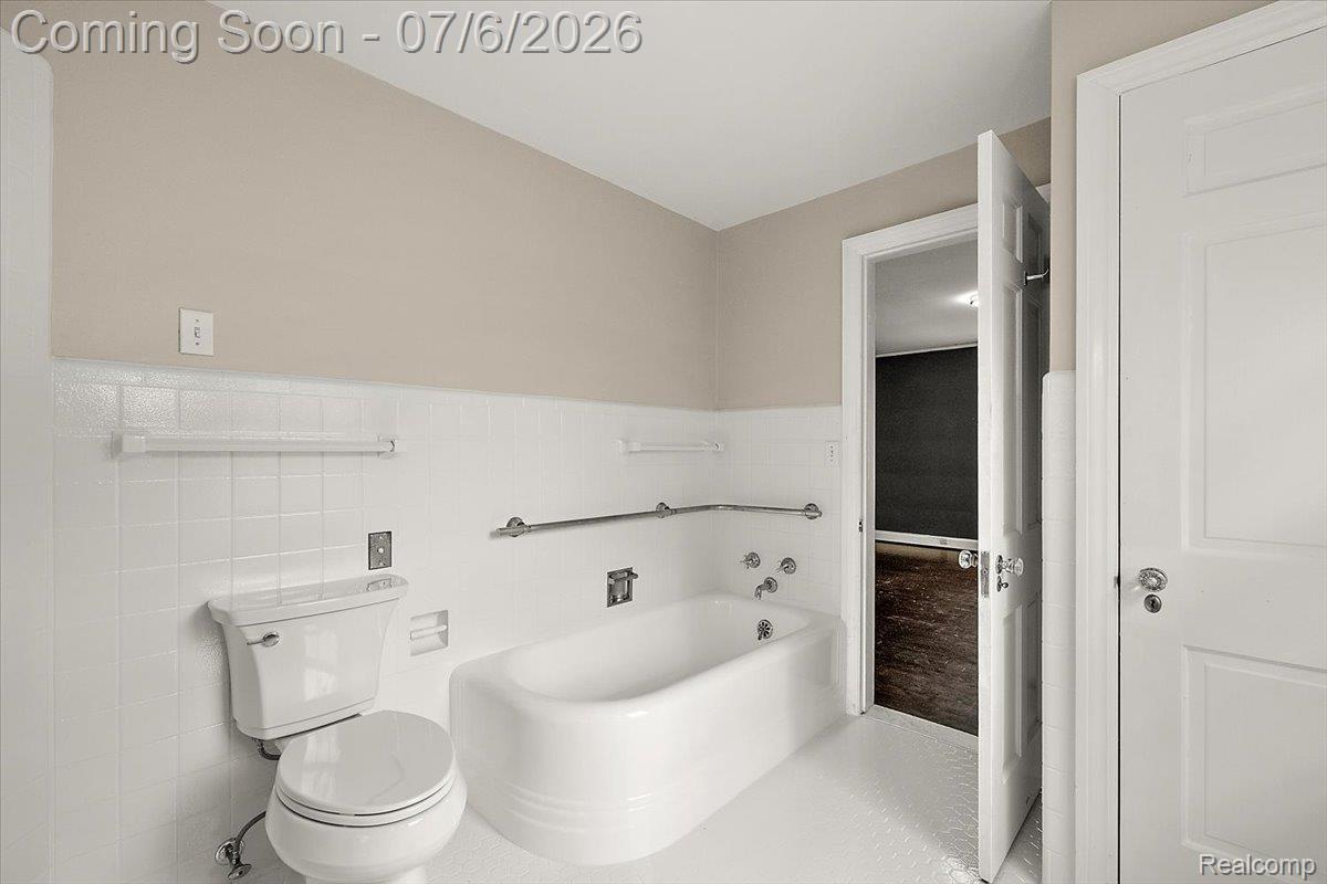 1051 Devonshire Road Grosse Pointe, MI 48230 - Photo 39 of 98 Bathroom featuring a white bathtub, white toilet, and white tile wainscoting