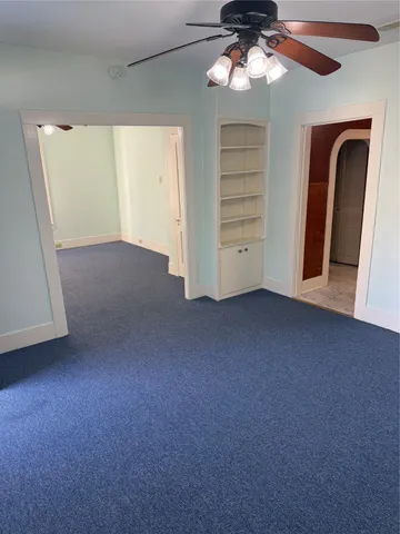 a view of a livingroom with a ceiling fan and window
