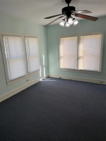 en empty room with windows and fan