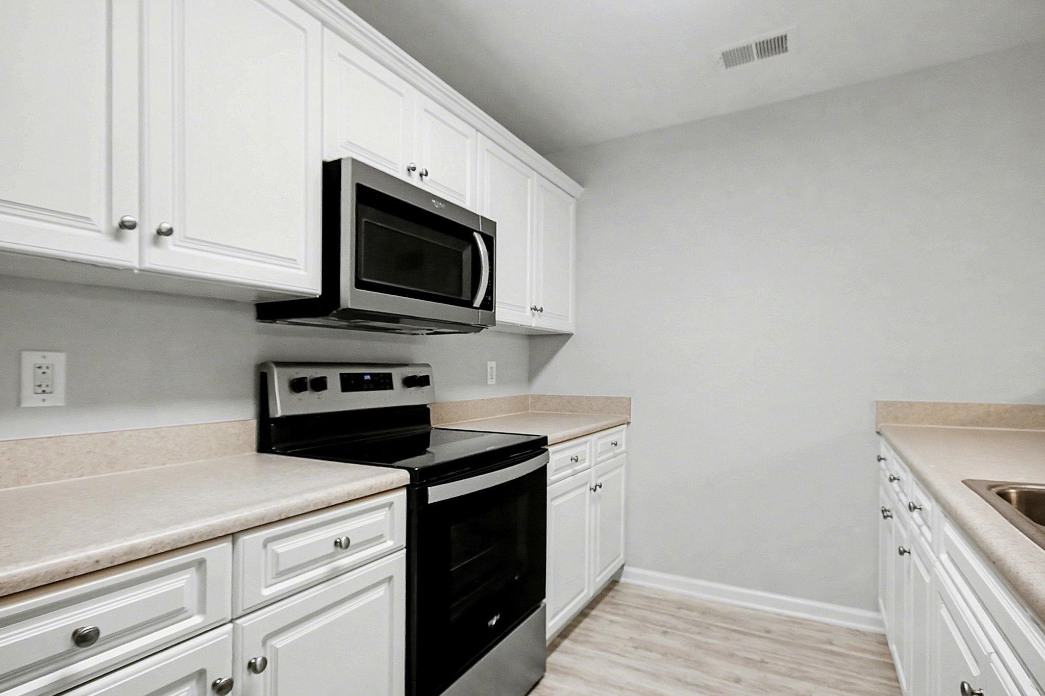 4853 Meadowsweet Drive, Unit 1807 Myrtle Beach, SC 29579 - Photo 11 of 40 Kitchen featuring stainless steel appliances, white cabinetry, light countertops and light wood-style flooring