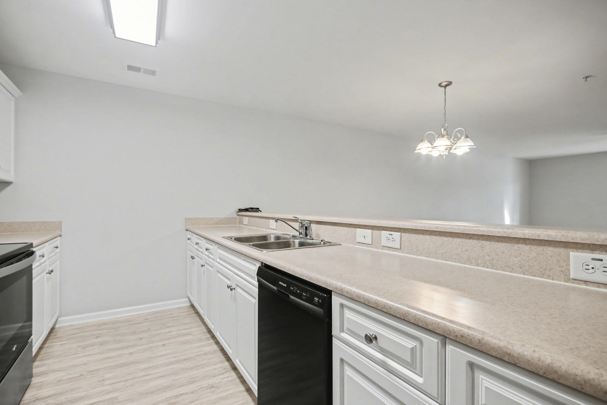 4853 Meadowsweet Drive, Unit 1807 Myrtle Beach, SC 29579 - Photo 12 of 40 Kitchen featuring stainless steel appliances, white cabinetry, light countertops and light wood-style flooring