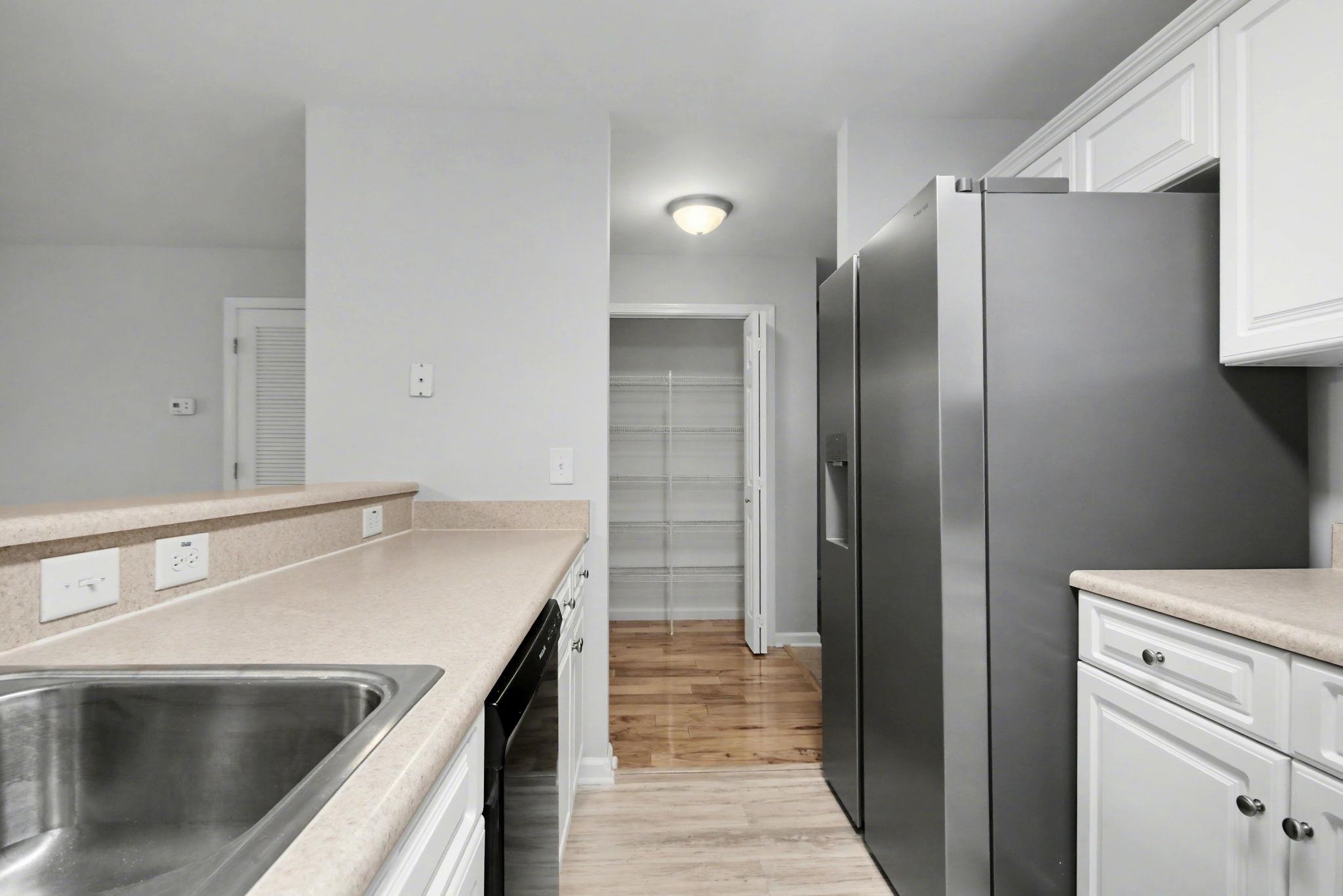 4853 Meadowsweet Drive, Unit 1807 Myrtle Beach, SC 29579 - Photo 13 of 40 Kitchen featuring stainless steel appliances, white cabinetry, light countertops and light wood-style flooring