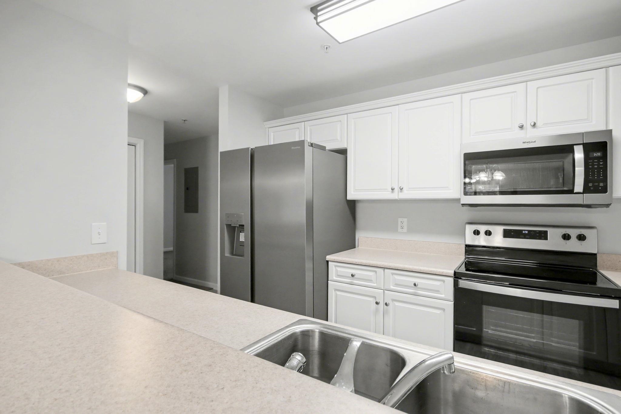 4853 Meadowsweet Drive, Unit 1807 Myrtle Beach, SC 29579 - Photo 15 of 40 Kitchen featuring stainless steel appliances, white cabinetry, light countertops and light wood-style flooring