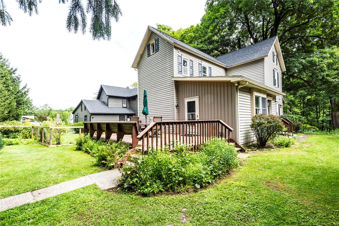 100 Creek Road Bangor, PA 18013 - Photo 11 of 51 A verdant lawn surrounds a home with an inviting wooden deck, perfect for outdoor enjoyment.