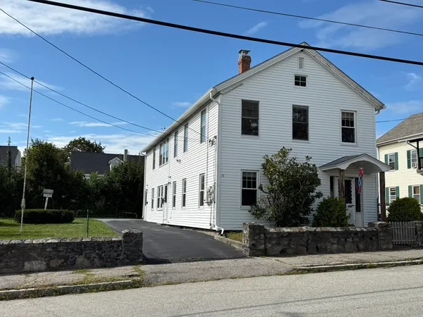 a view of a white house with a yard and plants