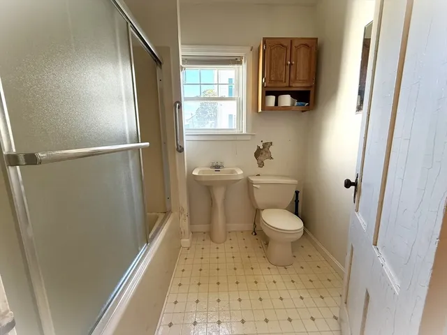 a bathroom with a toilet a window and vanity