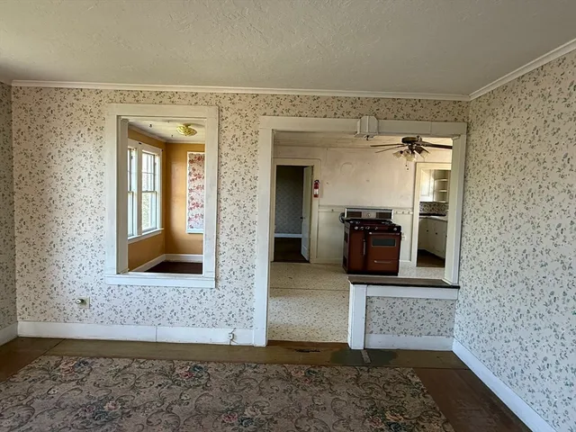 a view of a hallway with wooden floor and a living room