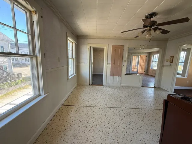 a view of a livingroom with a chandelier fan and windows