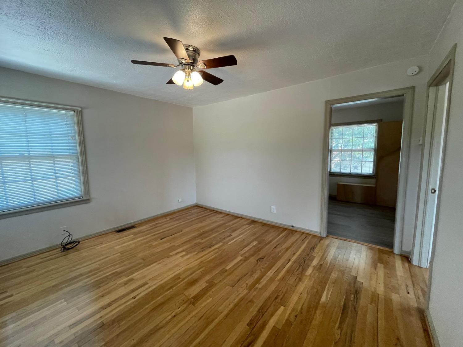 3018 29th Street Lubbock, TX 79410 - Photo 3 of 14 a view of empty room with wooden floor and fan