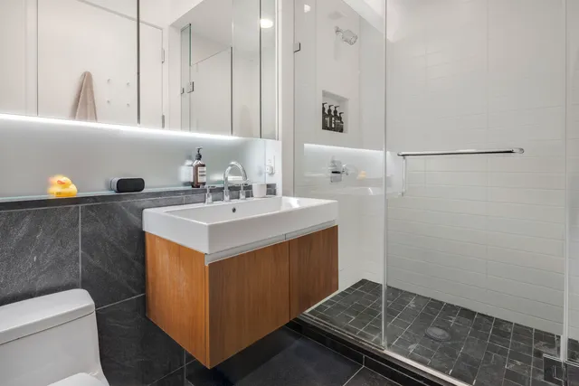 a bathroom with a double vanity sink toilet mirror and bathtub