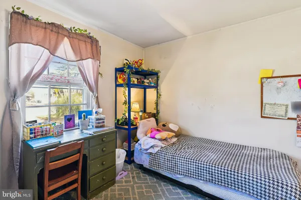 a view of a bedroom with baby crib and windows
