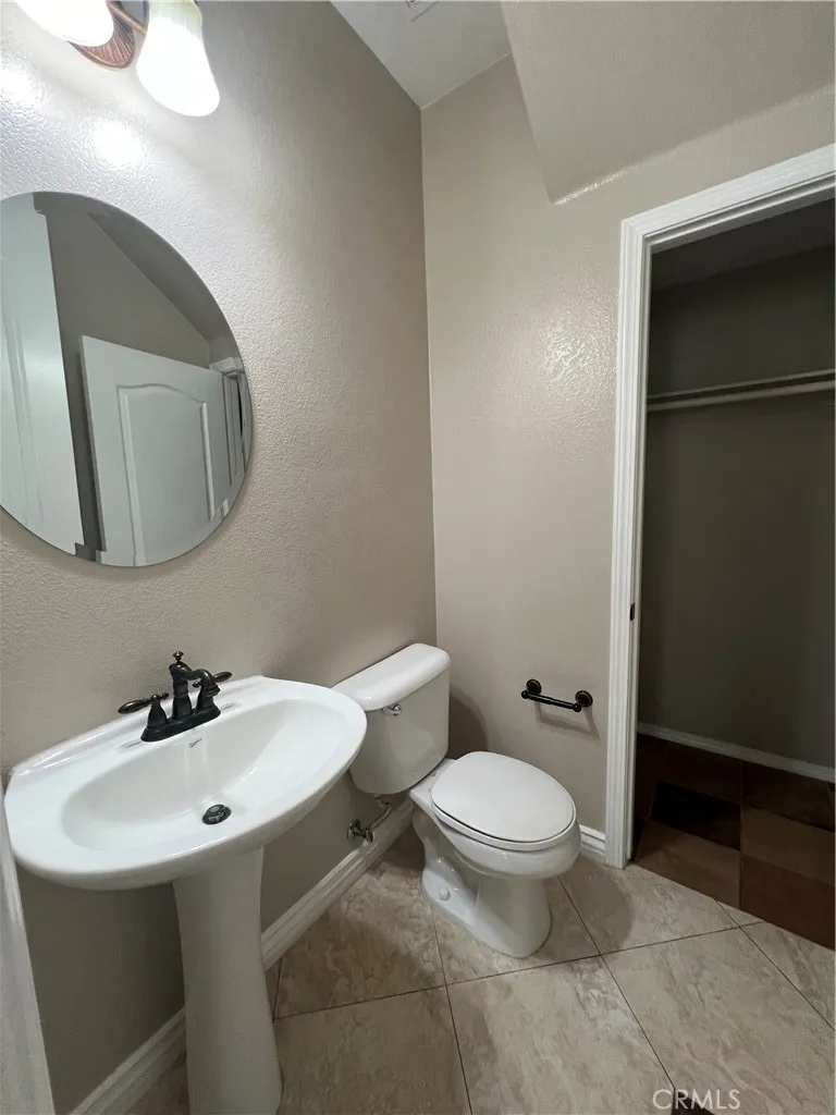 7161 East Avenue, Unit 104 Rancho Cucamonga, CA 91730 - Photo 7 of 18 a bathroom with a toilet a sink and mirror