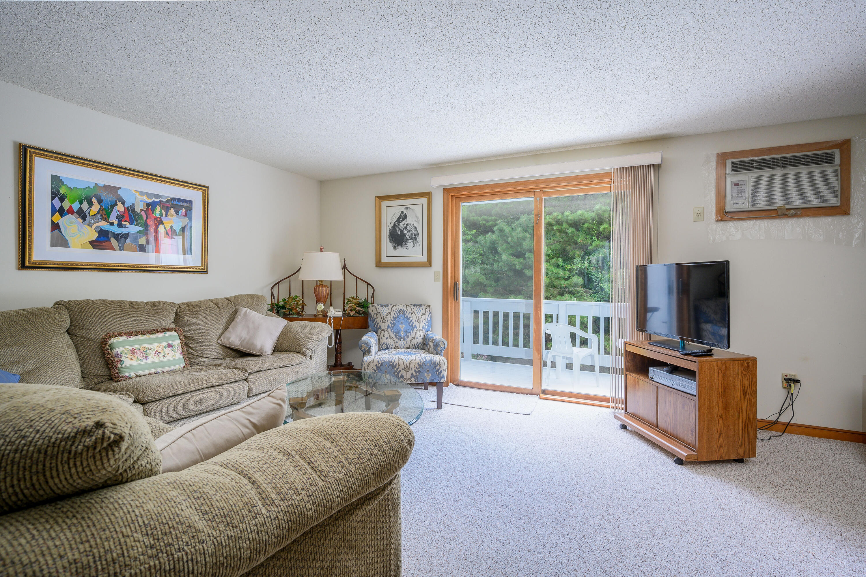 174 Lowell Road, Unit N102 Mashpee, MA 02649 - Photo 12 of 35 a living room with furniture a flat screen tv and a large window