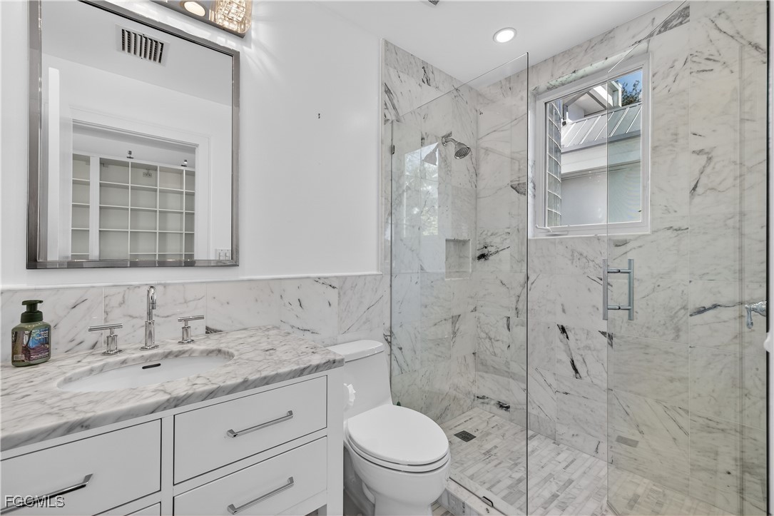 3402 West Riverside Drive Fort Myers, FL 33901 - Photo 38 of 50 a bathroom with a granite countertop sink toilet and shower