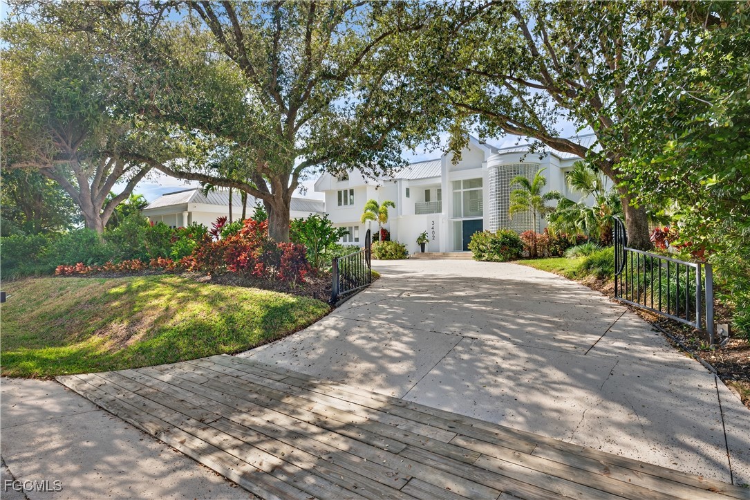 3402 West Riverside Drive Fort Myers, FL 33901 - Photo 47 of 50 a front view of a house with a garden and trees