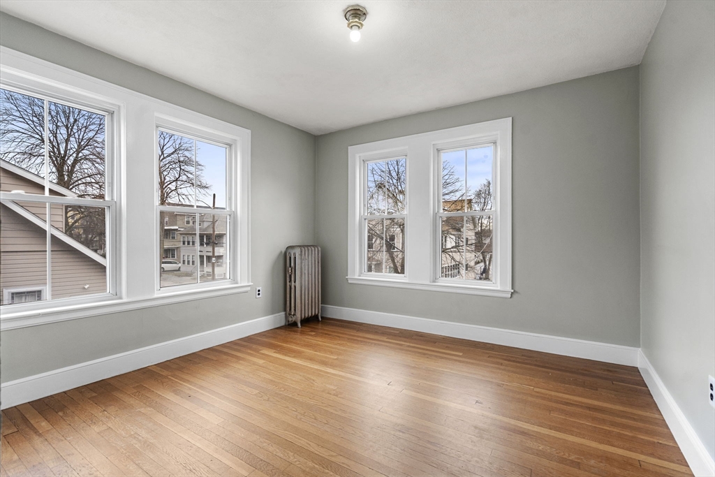 76 Myrtle Street Lynn, MA 01905 - Photo 12 of 27 a view of an empty room with wooden floor and a window