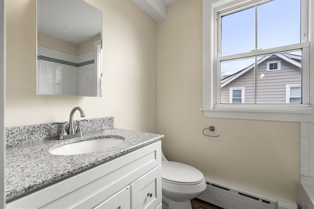 76 Myrtle Street Lynn, MA 01905 - Photo 13 of 27 a bathroom with a granite countertop toilet sink and mirror