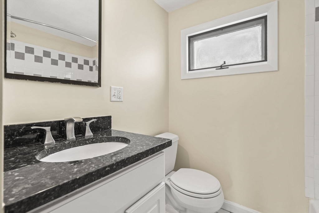 76 Myrtle Street Lynn, MA 01905 - Photo 20 of 27 a bathroom with a granite countertop sink mirror vanity and toilet