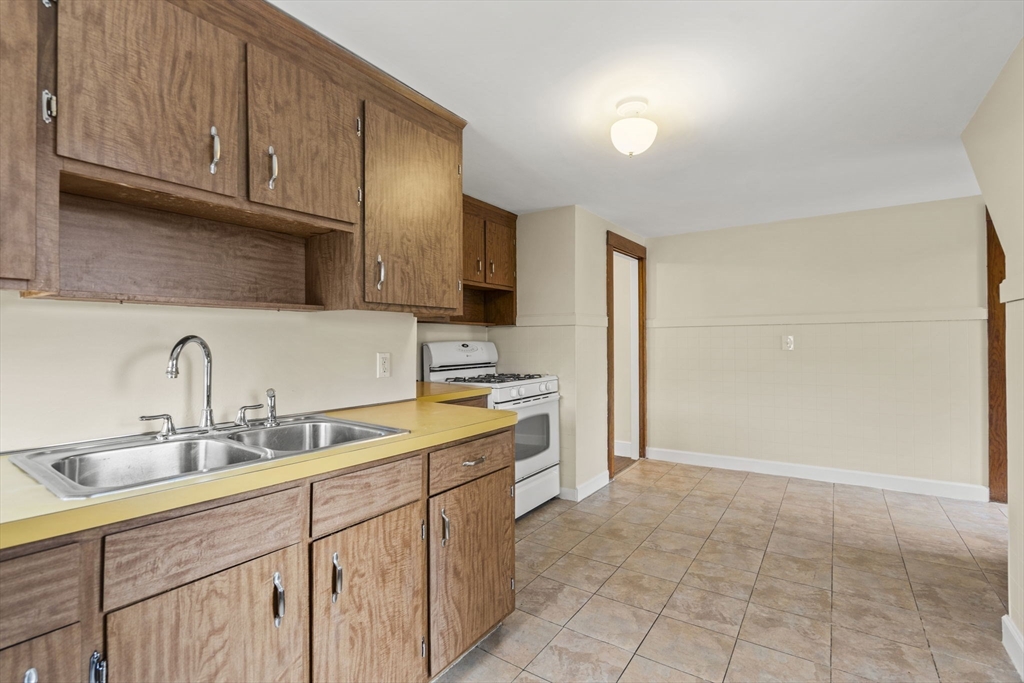76 Myrtle Street Lynn, MA 01905 - Photo 21 of 27 a kitchen with stainless steel appliances granite countertop a sink and cabinets