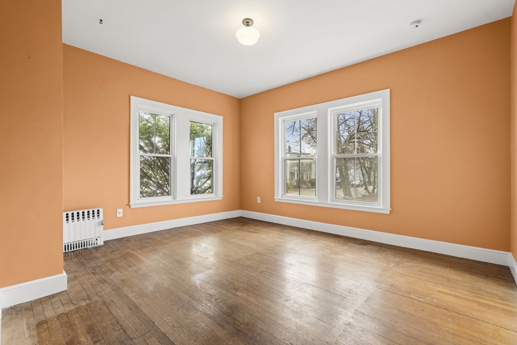 76 Myrtle Street Lynn, MA 01905 - Photo 3 of 27 a view of an empty room with a window and wooden floor