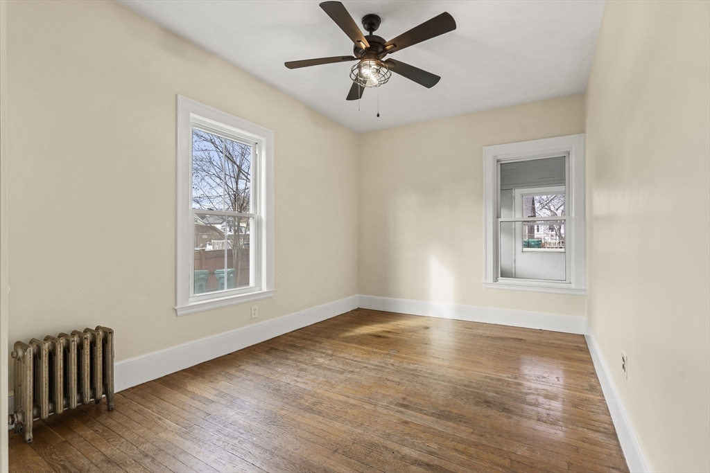 76 Myrtle Street Lynn, MA 01905 - Photo 4 of 27 a view of an empty room with window and wooden floor