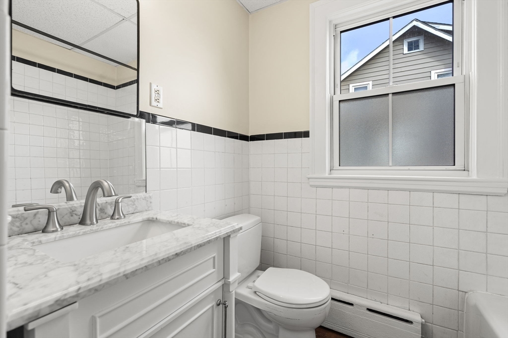76 Myrtle Street Lynn, MA 01905 - Photo 5 of 27 a bathroom with a granite countertop toilet sink and mirror