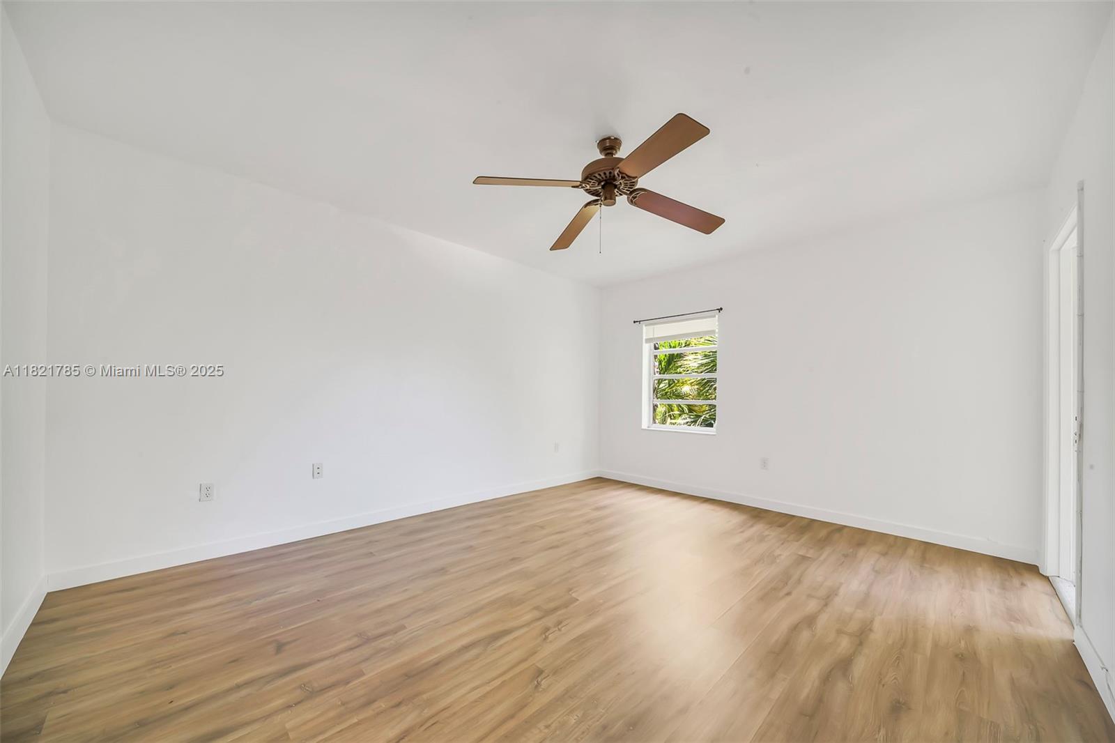 8335 Southwest 72nd Avenue, Unit 315D Miami, FL 33143 - Photo 20 of 28 an empty room with wooden floor and windows