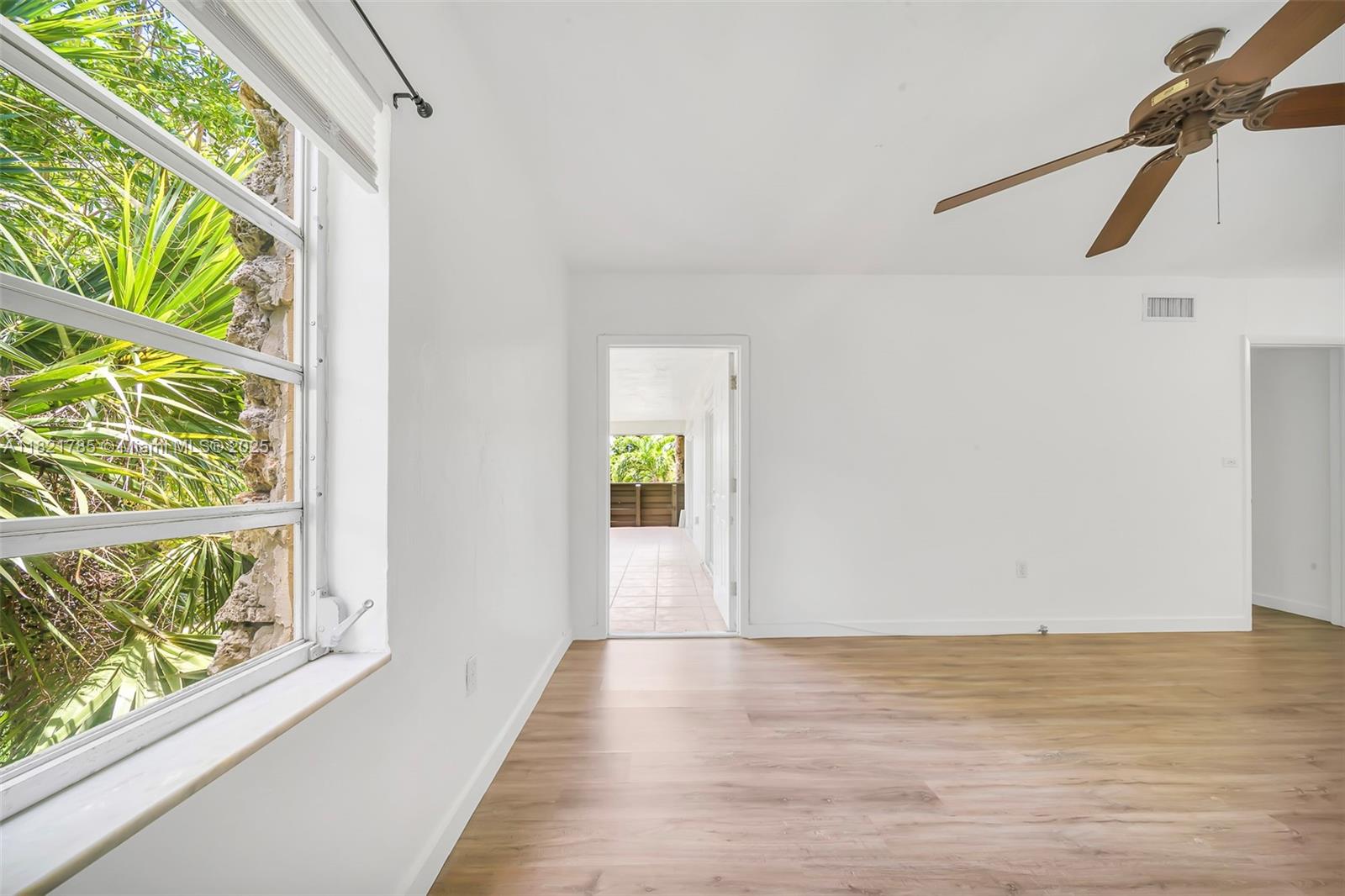 8335 Southwest 72nd Avenue, Unit 315D Miami, FL 33143 - Photo 22 of 28 a view of an empty room with wooden floor and windows