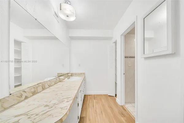 a bathroom with a granite countertop sink a vanity and mirror