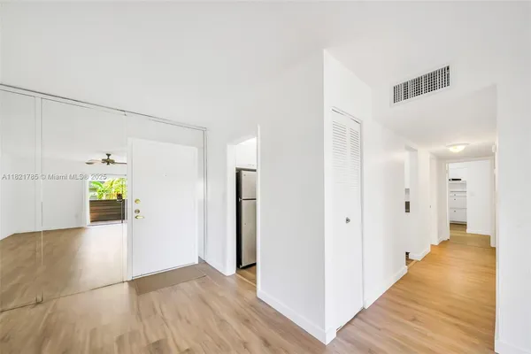 a view of a hallway with wooden floor and staircase