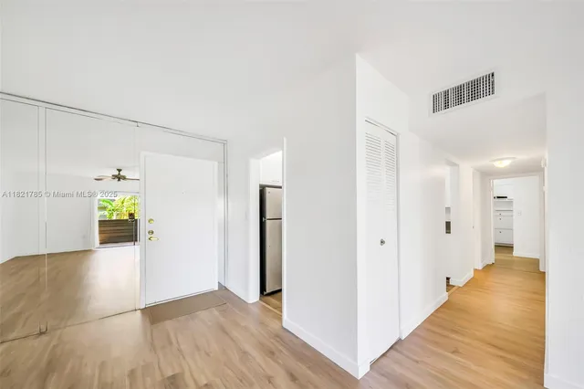 a view of a hallway with wooden floor and staircase