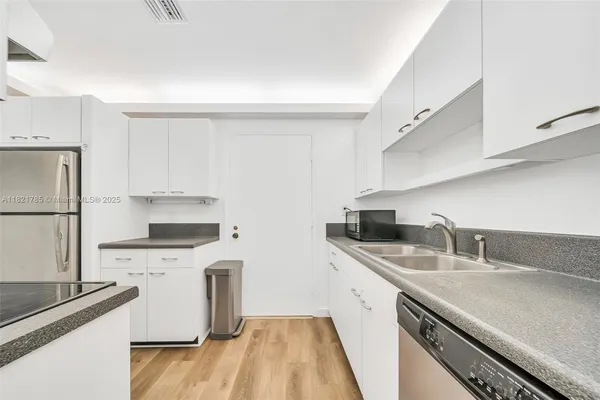 a kitchen with stainless steel appliances a sink a stove and a refrigerator