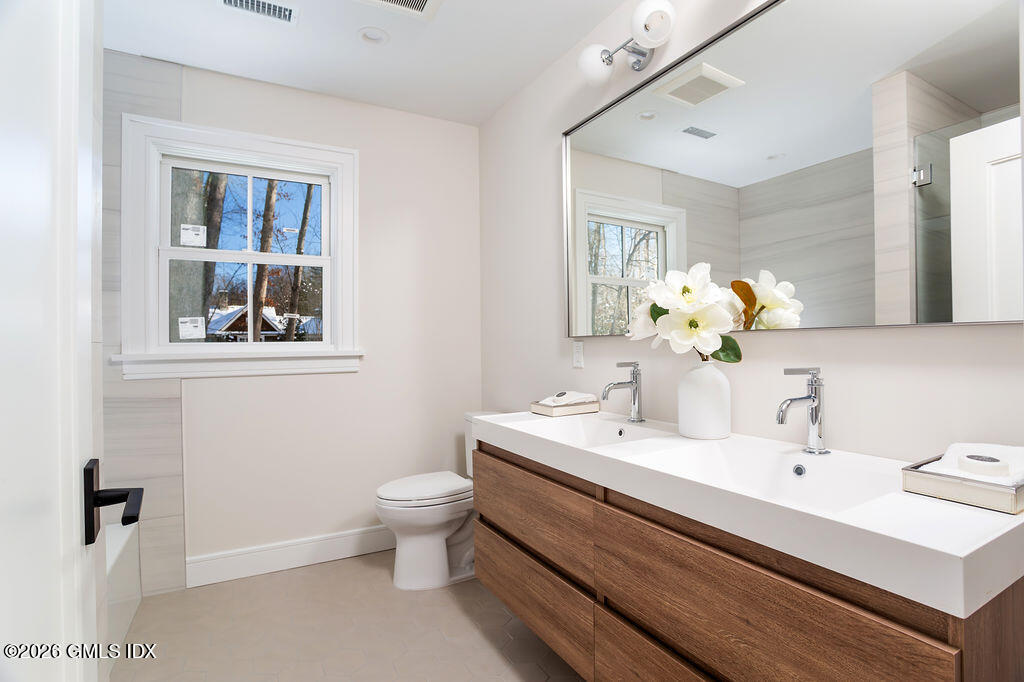 49 Salisbury Road Darien, CT 06820 - Photo 18 of 40 a bathroom with a sink mirror and toilet