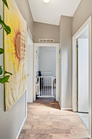 4296 Maple Lane Cedar City, UT 84721 - Photo 21 of 44 Hallway with wood-finish flooring, light grey painted walls, white trim, and a ceiling-mounted light fixture