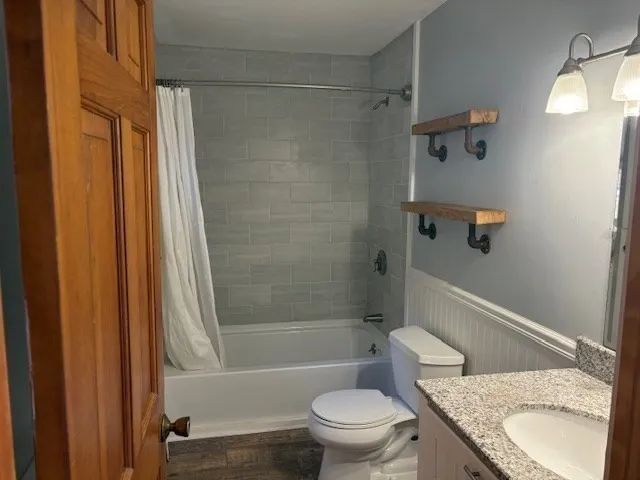 a bathroom with a granite countertop toilet sink and shower