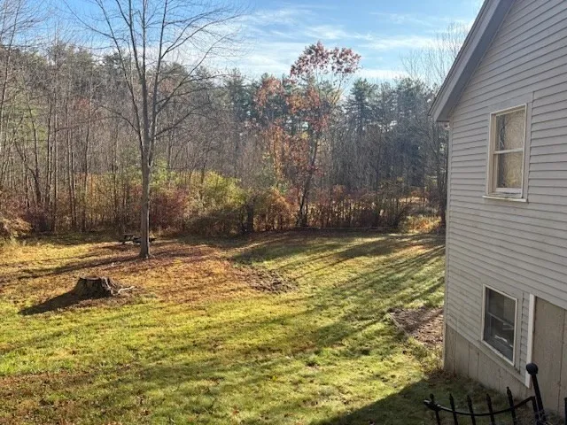 a view of swimming pool next to a brick house with large trees