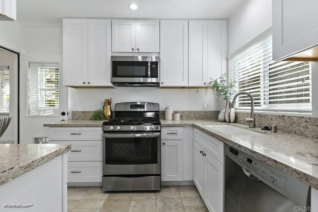 1453-1455 Thomas Avenue San Diego, CA 92109 - Photo 12 of 37 a kitchen with white cabinets appliances and a sink
