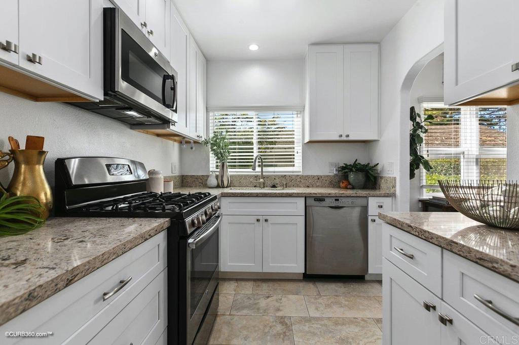 1453-1455 Thomas Avenue San Diego, CA 92109 - Photo 13 of 37 a kitchen with granite countertop cabinets stainless steel appliances and a sink