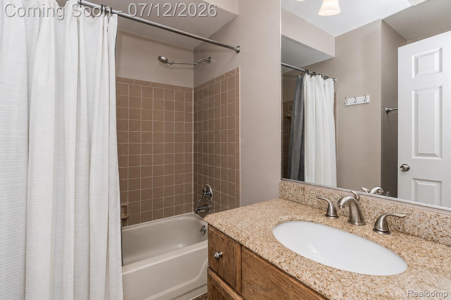 2033 Avonstoke Road Rochester, MI 48307 - Photo 22 of 26 Bathroom featuring a granite-finish countertop with an undermount sink, brushed nickel faucet, and a large mirror