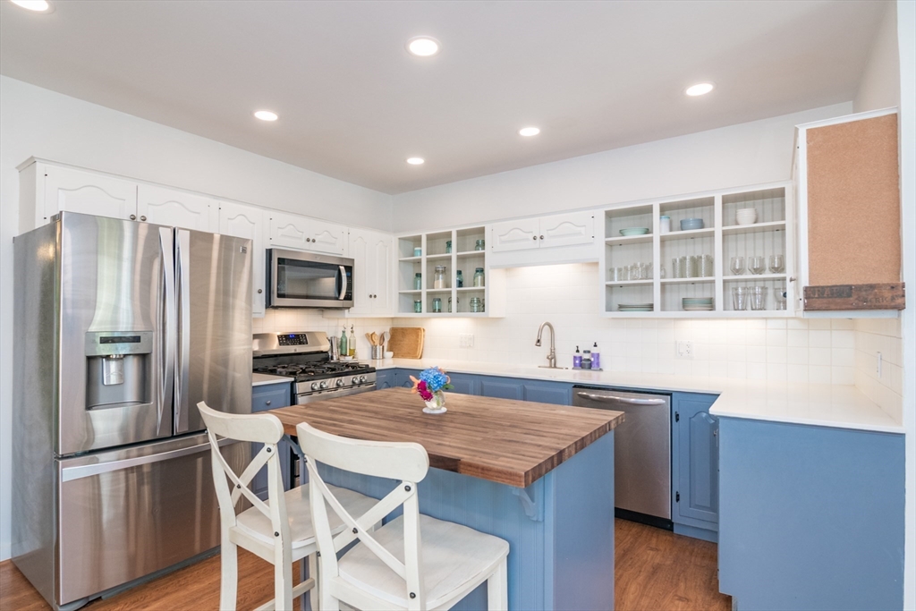 116 High Street Amherst, MA 01002 - Photo 12 of 42 a kitchen with stainless steel appliances granite countertop a kitchen island hardwood floor and a sink