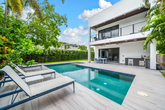 a kitchen with kitchen island granite countertop a sink a counter top space cabinets and stainless steel appliances