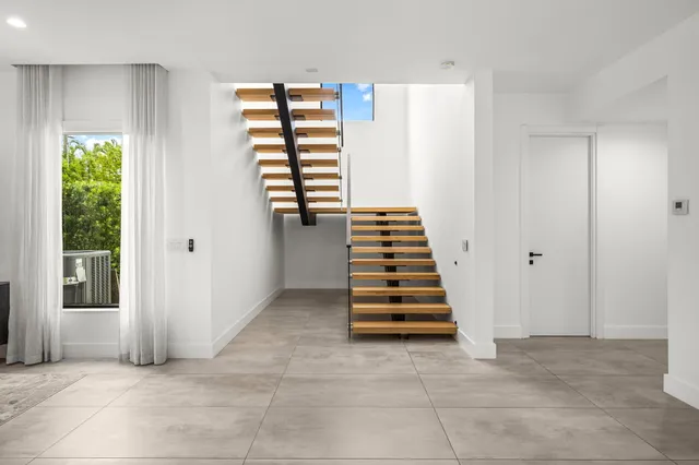 an aerial view of residential houses with outdoor space and trees