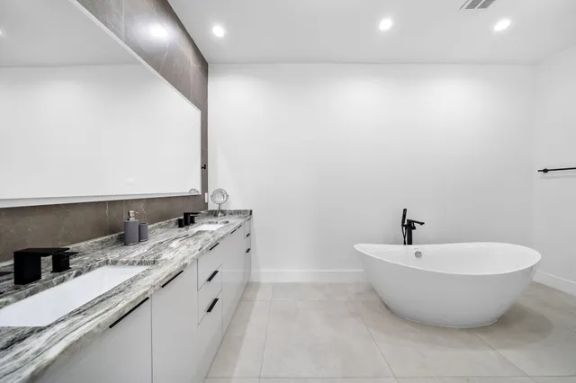 a bathroom with a granite countertop shower and a sink