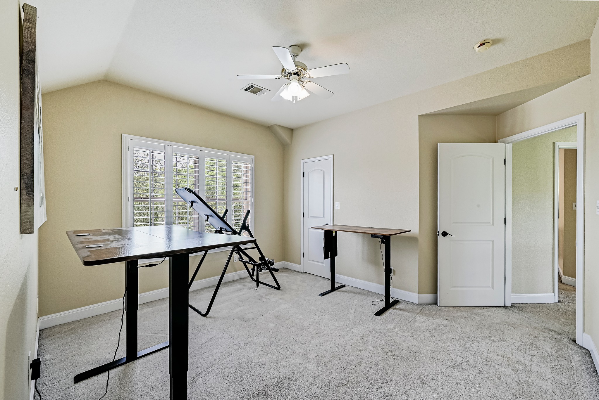 2408 Amen Corner Road Pflugerville, TX 78660 - Photo 27 of 40 Carpeted room featuring a window with white shutters, a ceiling fan, and multiple doors