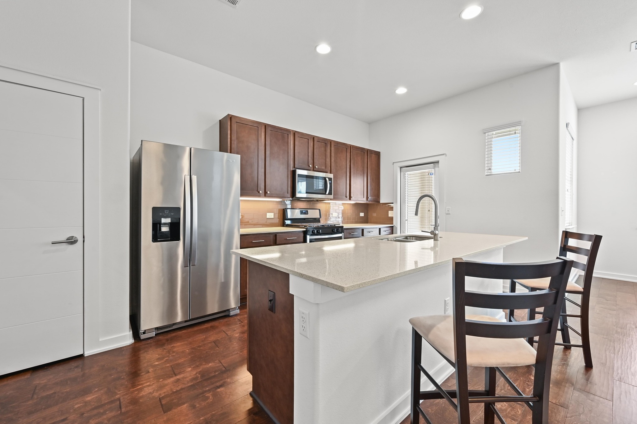 8901 Parker Ranch Circle, Unit A Austin, TX 78748 - Photo 12 of 31 Gleaming hardwood floors and a spacious island anchor this contemporary kitchen workspace.