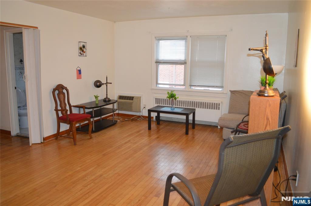 721 Broad Street, Unit 5A Newark, NJ 07102 - Photo 2 of 6 a living room with furniture and a gym machine next to a window