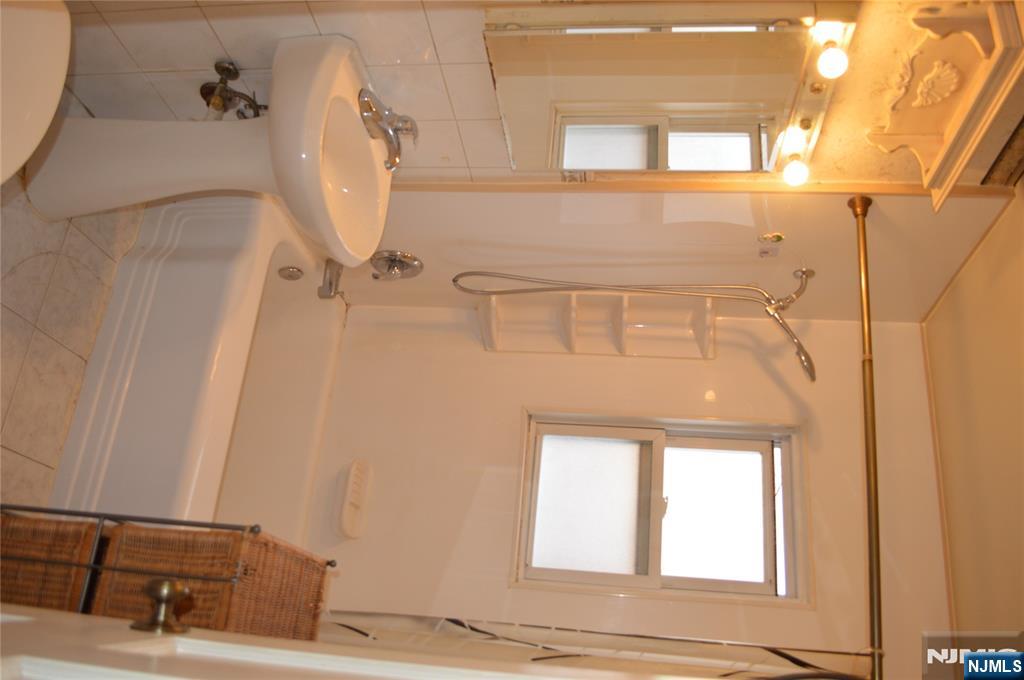 721 Broad Street, Unit 5A Newark, NJ 07102 - Photo 5 of 6 a bathroom with a sink a toilet and shower