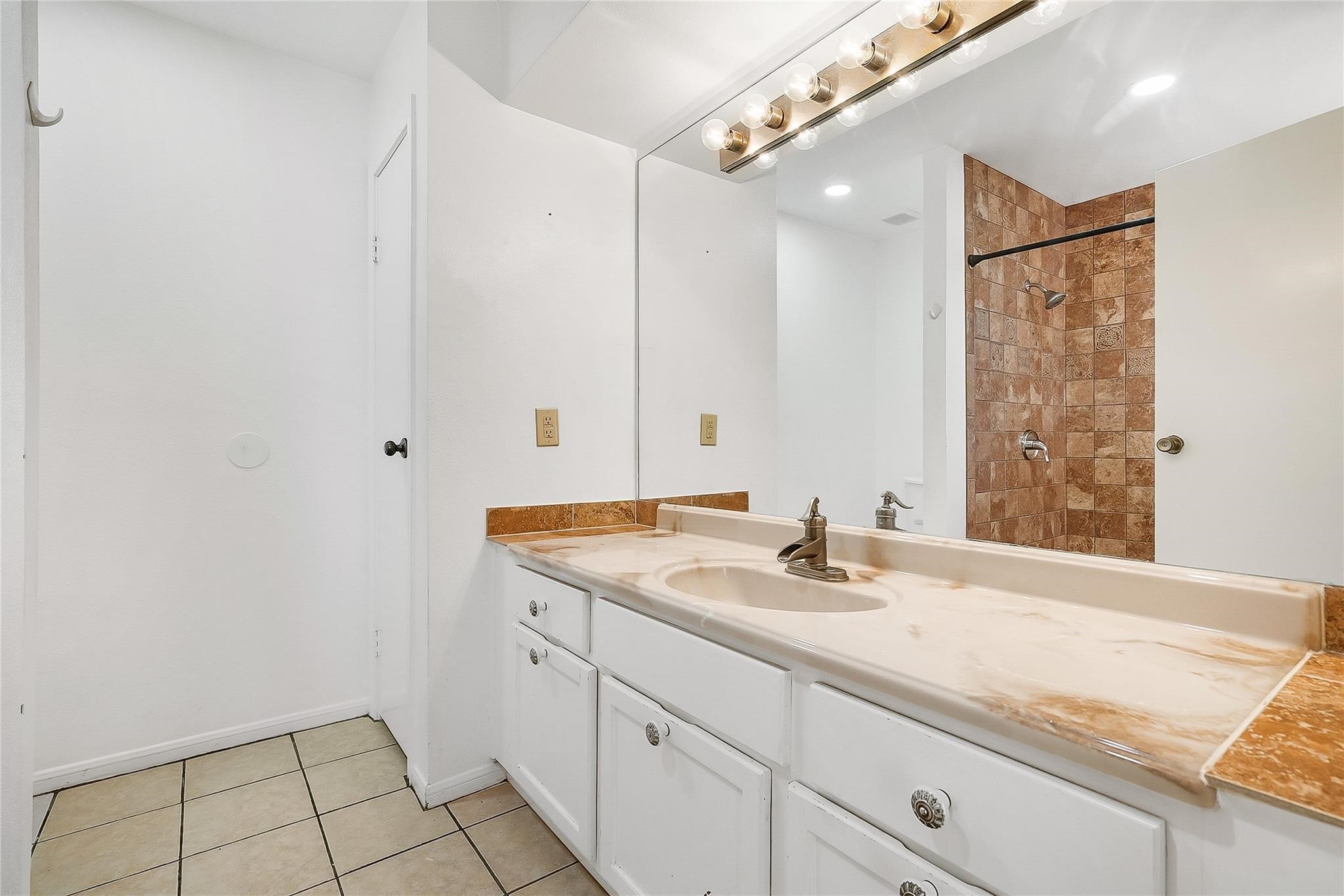 3100 Walnut Bend Lane, Unit 116 Houston, TX 77042 - Photo 11 of 15 a bathroom with a granite countertop sink a mirror and shower